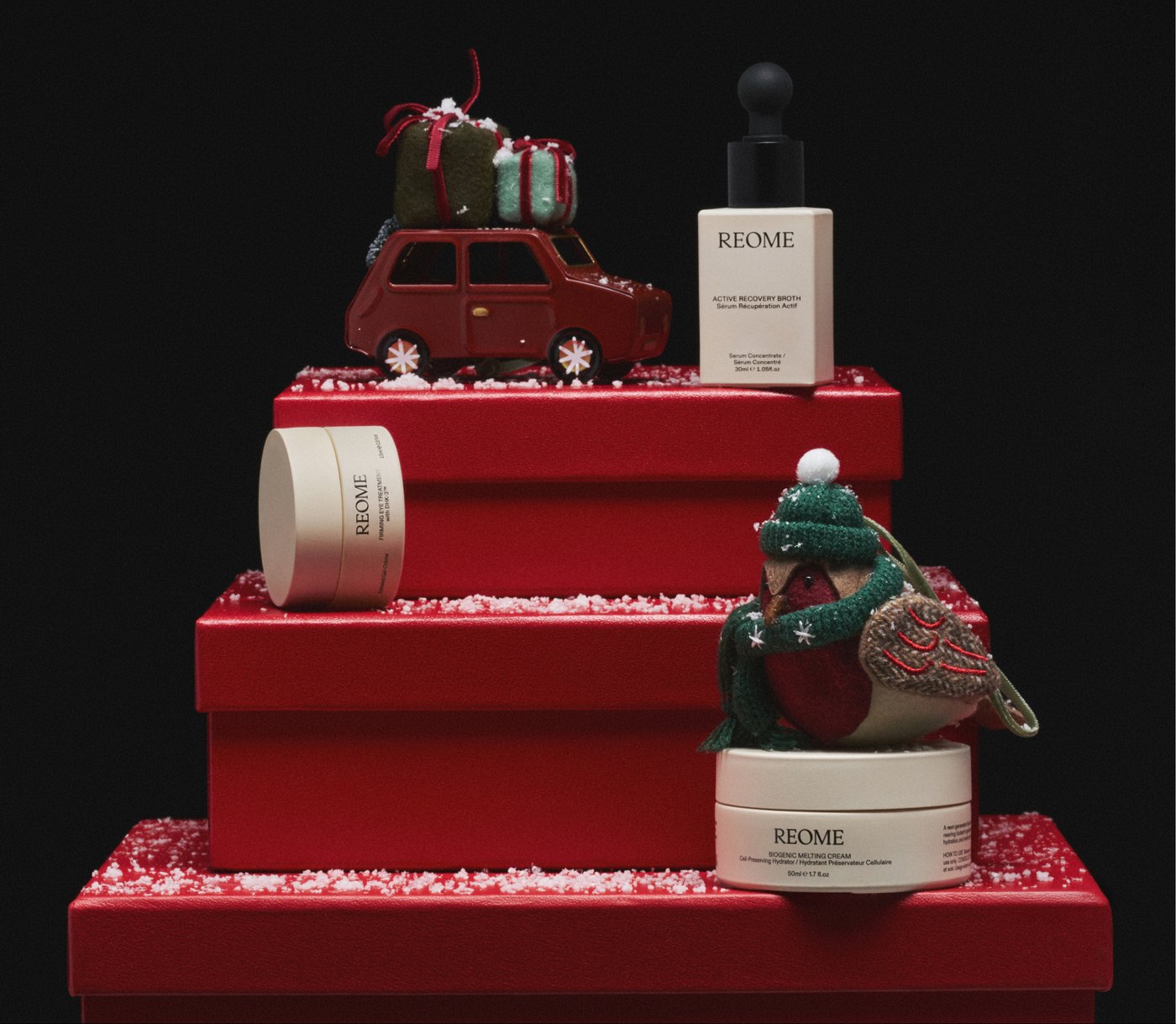 Skincare products on red gift boxes against a black background