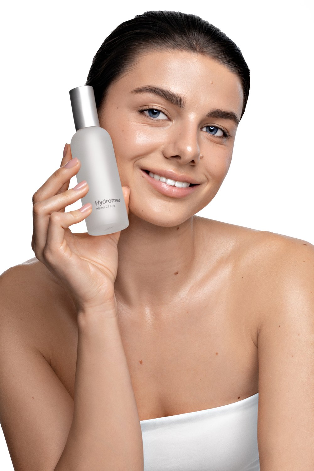 Model holding a Hydromer skincare bottle next to her face