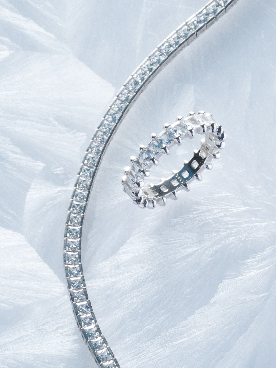 Diamond tennis bracelet and eternity ring on frosted glass