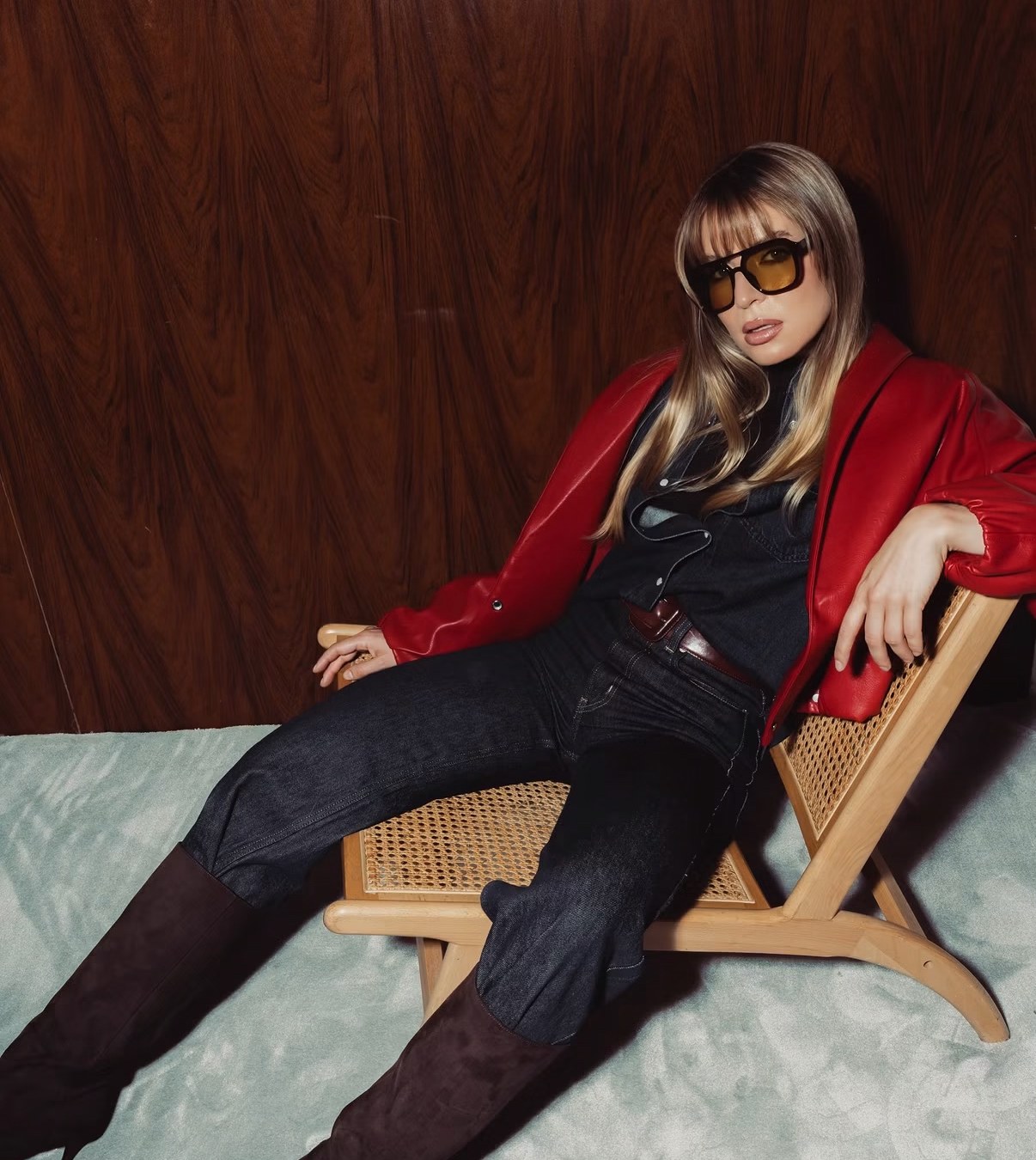 Model in a red leather jacket reclining on a cane chair, shot by a previous workshop participant