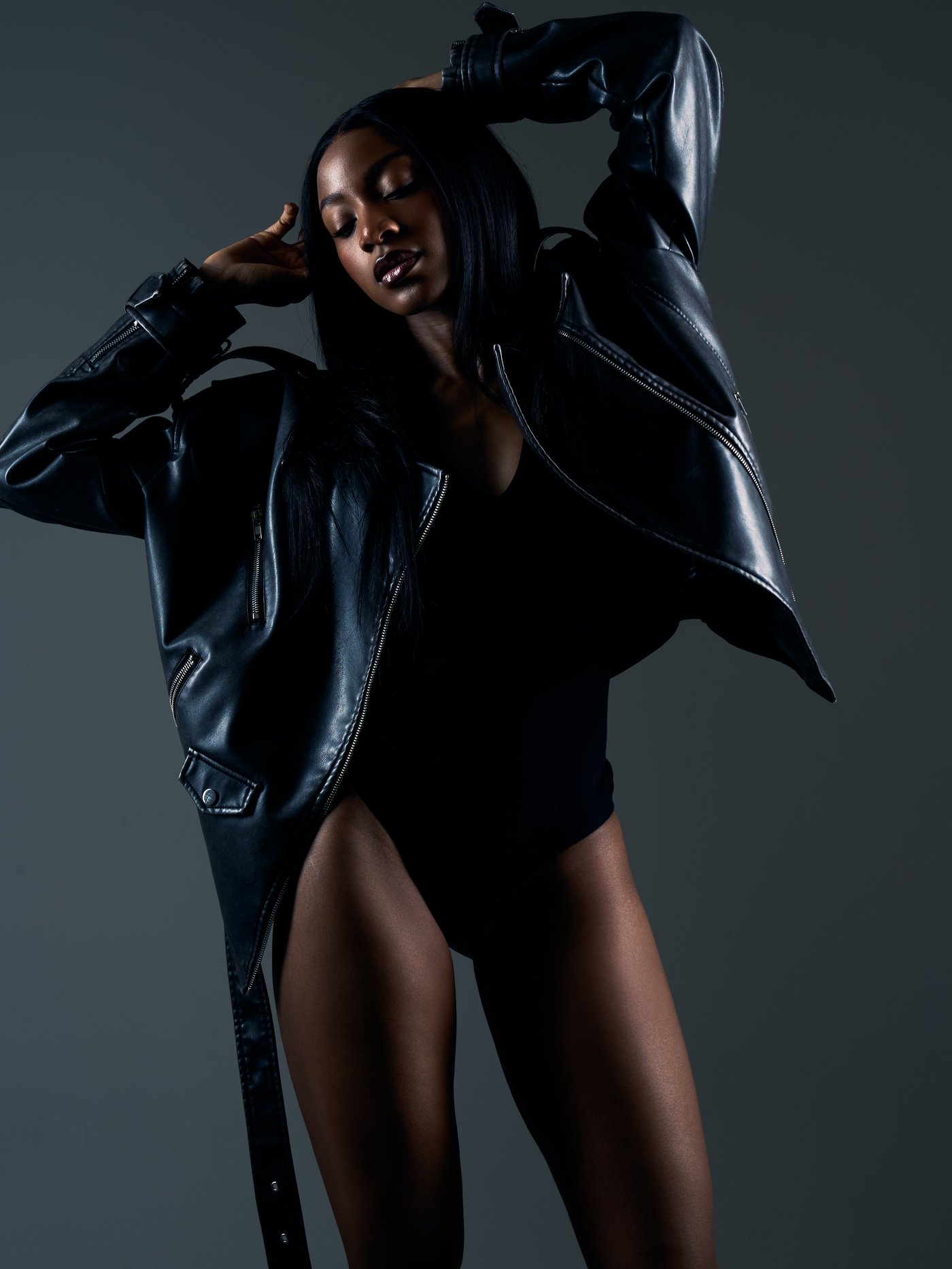 Studio portrait in a black leather jacket, shot on a dark grey backdrop